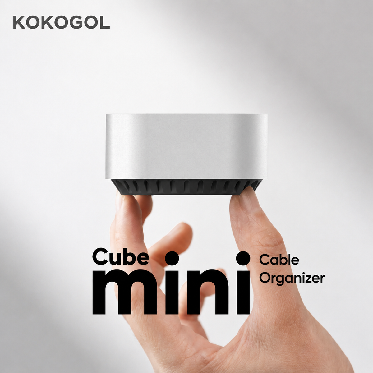 Compact weighted Cube Mini cable organizer held in one hand