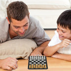 Father and son playing mini magnetic chess on the floor